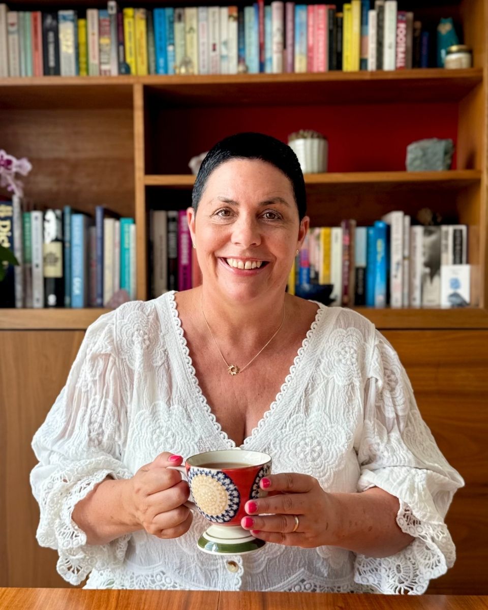 Nikki Hastings from Sunshine Holistics smiling and holding a herbal tea